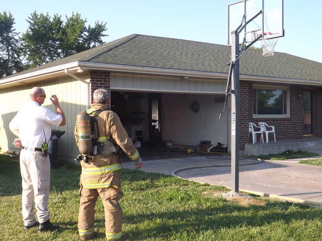 Fire officials peer into the kitchen of a home in southeast Topeka while investigating a kitchen fire on Sunday.