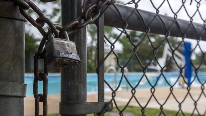 A lock seals the entrance to the Parque Zaragoza pool in East Austin. The pool is one of 14 in Austin that remains closed this summer due to a shortage of lifeguards.
