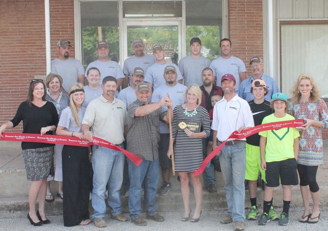 Pictured are Tunnell Construction and Roofing employees cutting the ribbon with the Brownwood Area Chamber of Commerce ambassadors and staff.