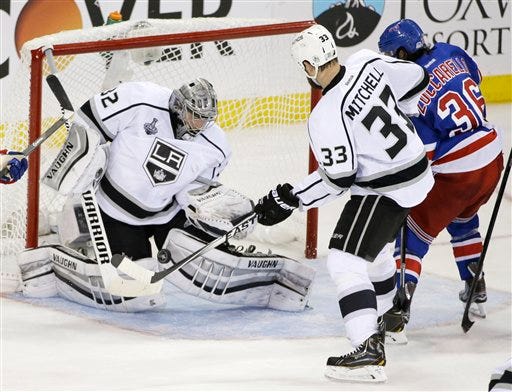 Los Angeles Kings goalie Jonathan Quick (32) blocks a shot by New York Rangers right wing Mats Zuccarello (36) as Kings defenseman Willie Mitchell (33) helps defend in the second period during Game 3 of the NHL hockey Stanley Cup Final, Monday, June 9, 2014, in New York. (AP Photo/Frank Franklin II)