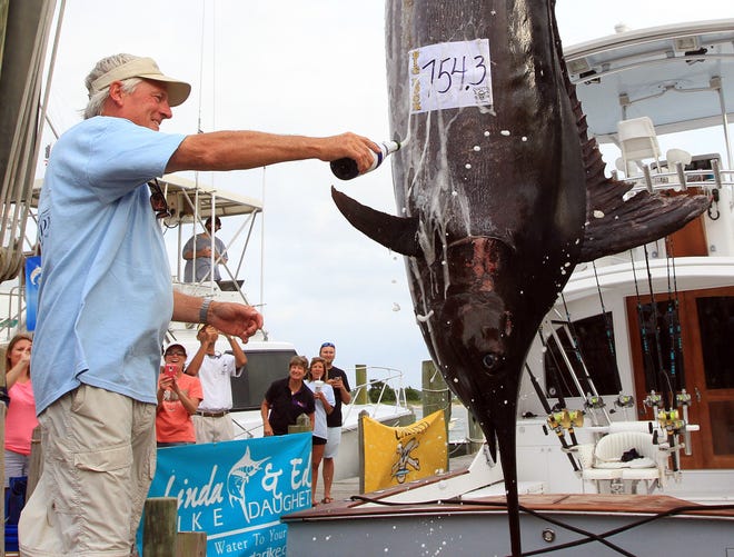 Casey Wagner, captain of the boat Inspiration, sprays champagne on his 754.3-pound blue marlin Monday at the Big Rock Blue Marlin Fishing Tournament in Morehead City. The fish is in first place of the million-dollar tournament that runs through Saturday.