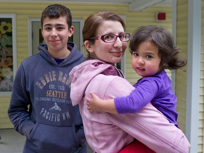 Lisa Flores poses with her daughter, Viviana, 2 and son, Dominic, 15, on Thursday, June 5, 2014, in Juneau, Alaska. Flores recently changed her daughter's middle name to Awesome with some persuasion from Dominic.