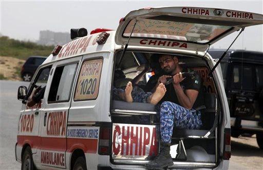 An ambulance rushes to a hospital after gunmen attacked a training center for airport security personnel in Karachi, Pakistan, Tuesday, June 10, 2014. Gunmen in Pakistan attacked a training facility near the Karachi airport on Tuesday, a spokesman said. The facility is roughly one kilometer (half mile) from the Karachi international airport.