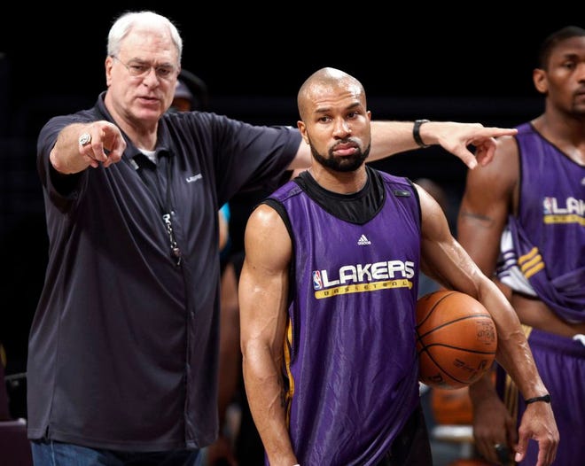 In this file photo from June 16, 2010, then Los Angeles Lakers coach Phil Jackson, left, directs Derek Fisher during NBA basketball practice in Los Angeles. Fisher was named head coach of the New York Knicks on Tuesday, June 10, 2014. Jackson is Knicks president.