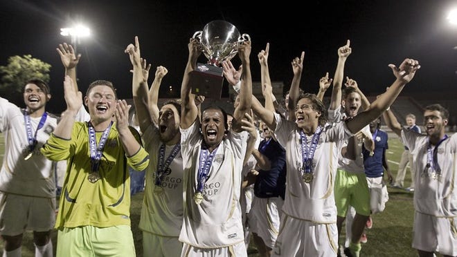 Austin Aztex team captain Zack Pope hoists the championship trophy as the team celebrates winning the Premier Development League championship last year. The Aztex are moving up to the USL Pro League starting in 2015.
