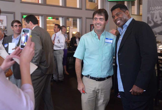 Paul Coker, left, takes a photo with Herschel Walker at walkers restaurant on Thursday, June 12, 2014, in Athens, Ga.  (Richard Hamm/Staff) OnlineAthens / Athens Banner-Herald
