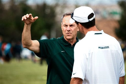Michigan State University Football Head Coach Mark Dantonio talks to an assistant coach during the Sound Mind Sound Body Football Camp at Chandler Park Academy High School in Harper Woods, Mich. on Thursday, June 12, 2014. (AP Photo/Detroit Free Press, Kimberly P. Mitchell) DETROIT NEWS OUT; NO SALES