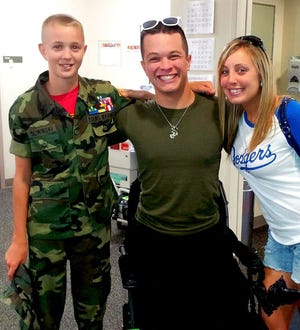 Marine Cpl. Tyler Southern, a triple amputee, will be the emcee at Saturday's race. He is pictured with his wife, Ashley, and Luke Sliwinski at Walter Reed Military Medical Center in Bethesda, Maryland.