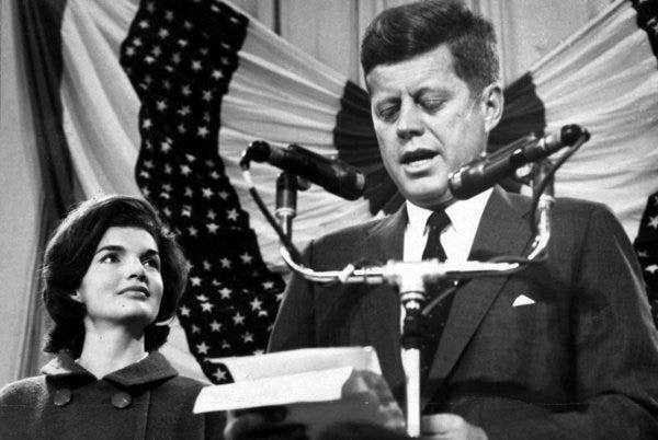 9 November 1960 -- President-elect John F. Kennedy gives a speech on the podium at the Hyannisport Armory the day he is elected as President of the United States. Jacqueline Kennedy stands to President-elect Kennedy's left. Hyannisport Armory, Hyannisport, Massachusetts.