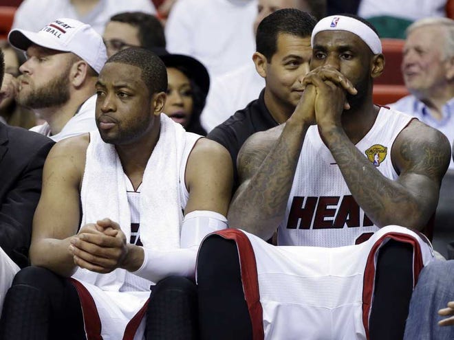 Miami Heat forward LeBron James, right and guard Dwyane Wade sit on the bench during the last minutes in the second half in Game 4 of the NBA basketball finals against the San Antonio Spurs, Thursday, June 12, 2014, in Miami. The Spurs defeated the Heat 107-86. (AP Photo/Lynne Sladky)