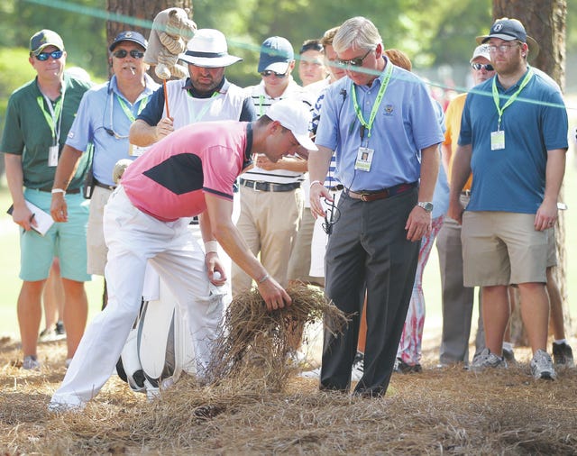 Golfer Martin Kaymer of Dusseldorf, Germany, moves pine straw under the watchful eye of USGA official Tom O' Toole Jr., after being forced to take a drop on a unplayable lie after hitting into a washout of pine straw on the fourth hole during the third round of the 2014 U.S. Open at Pinehurst No. 2 in Pinehurst, N.C., Saturday, June 14, 2014. (Robert Willett/Raleigh News & Observer/MCT)