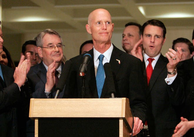Gov. Rick Scott flanked by senate president Don Gaetz, R-Niceville, left, and house speaker Will Weatherford, R-Wesley Chapel, speaks at the end of session on Friday, May 2, 2014, in Tallahassee, Fla. (AP Photo/Steve Cannon)