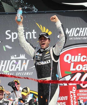Jimmie Johnson acknowledges the fans after winning the NASCAR Quicken Loans 400 auto race at Michigan International Speedway in Brooklyn, Mich., Sunday, June 15, 2014. (AP Photo/Bob Brodbeck)