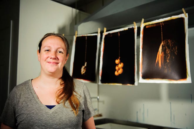 Heather Pyles poses next to images from her senior show that featured still gum prints of vegetables suspended from wooden frames with strings in the darkroom at Columbia College on Monday, June 9, 2014. Ryan Henriksen/Tribune June 2014/features/heather pyles rh