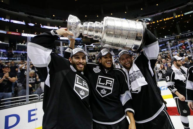 The Kings' Dwight King, from left, Jordan Nolan and Jake Muzzin hoist the Stanley Cup on Friday night.