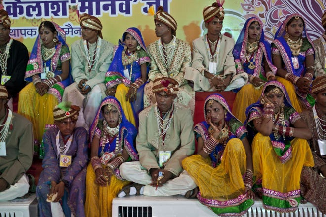 Indian brides and grooms wait to be married in a mass wedding of 100 couples in New Delhi. Social organizations set up such mass weddings to help families who can't afford a ceremony and an elaborate dowry.