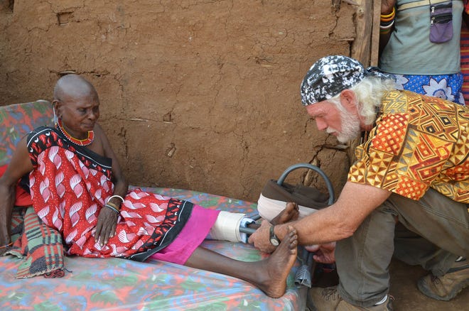 Dr. Scott Smith, right, who lives in Flagler Beach, works with an 80-year-old Maasai woman during a recent medical mission to Kenya. He is raising money to build the Mount Kilimanjaro Mission Hospital for a community that lacks sufficient medical care.