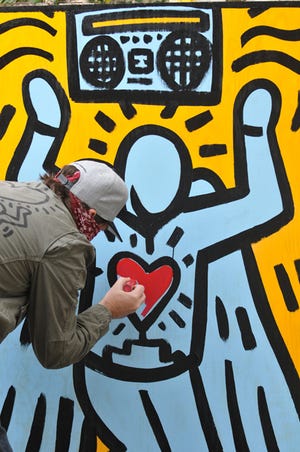 In this Jan. 29, 2014 file photo, the artist known as Keith Haring's Ghost paints a work called "Jordan Lives", in honor of Jordan Davis, the 17-year-old who was killed at a gas station during a dispute over loud music in 2012.