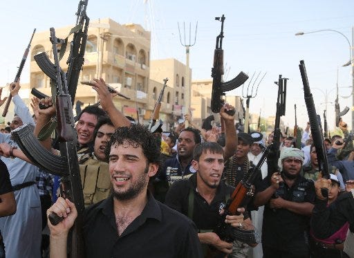 Shiite tribal fighters raise their weapons and chant slogans against the al-Qaida-inspired Islamic State of  Iraq  and the Levant (ISIL) in the northwest Baghdad's Shula neighborhood,  Iraq , Monday, June 16, 2014. Sunni militants captured a key northern Iraqi town along the highway to Syria early on Monday, compounding the woes of Iraq's Shiite-led government a week after it lost a vast swath of territory to the insurgents in the country's north. (AP Photo/ Karim Kadim)