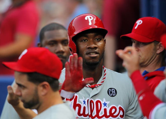 Phillies left fielder Domonic Brown celebrates with teammates after scoring on a wild pitch in the fourth inning Tuesday, July 17, 2014, in Atlanta.