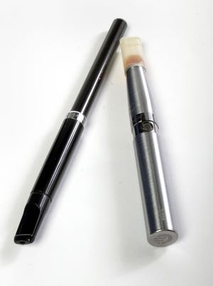 Two types  of electronic cigarettes, or e-cigarettes, are a cartridge type, left, and tank type, right. Tobacco companies are moving into sales of e-cigarettes.