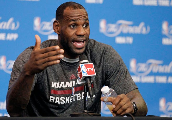 Miami Heat forward LeBron James responds to a question during a media availability session on Saturday, June 14, 2014, in San Antonio.