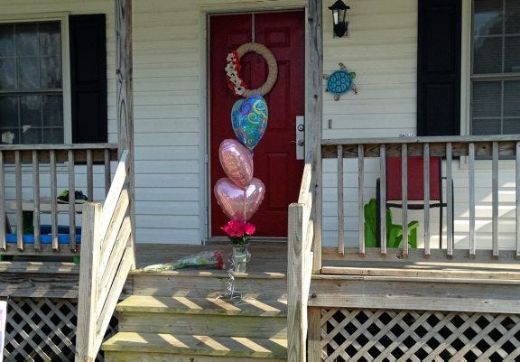 Flowers are placed outside a home on Fox Maple Terrace in Matoaca, the scene of a murder-sucide.