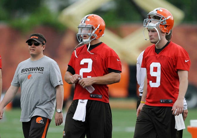 Cleveland Browns quarterback Johnny Manziel (2) walks off the field with quarterbacks coach Dowell Loggains, left, and quarterback Connor Shaw (9) after a mandatory minicamp practice at the NFL football team's facility in Berea, Ohio Tuesday, June 10, 2014. (AP Photo/Mark Duncan)