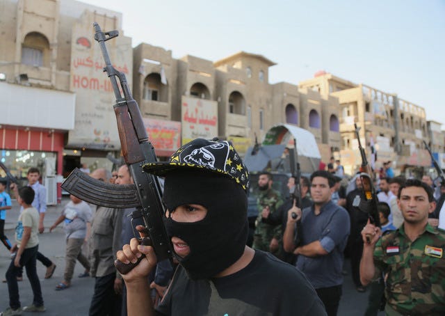 THE ASSOCIATED PRESS / Shiite tribal fighters raise their weapons and chant slogans against the al-Qaida-inspired Islamic State of Iraq and the Levant in the northwest Baghdad's Shula neighborhood, Iraq, on Monday. Sunni militants captured a key northern Iraqi town along the highway to Syria early on Monday, compounding the woes of Iraq's Shiite-led government a week after it lost a vast swath of territory to the insurgents in the country's north.