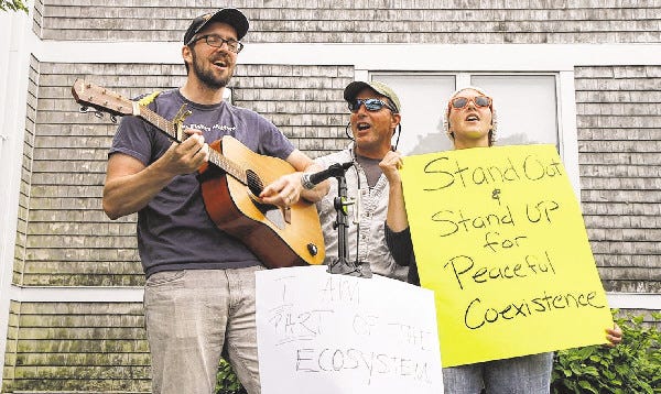 From left, Brett Tolley, Russel Kingman and Shannon Eldredge, all of Chatham, sing while protesting the refuge plan for the Monomoy Wildlife Refuge outside Chatham High School prior to a public hearing on the plan. Cape Cod Times/Shane Flanigan
CHATHAM -- 06/17/14 -- From left, Brett Tolley, Russel Kingman and Shannon Eldredge, all of Chatham, sing while protesting the refuge plan for the Monomoy Wildlife Refuge outside Chatham High School prior to a public hearing on the plan. Cape Cod Times/Shane Flanigan