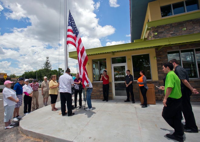 Residents from VFW Veterans Village in Ft. McCoy, performed a flag raising ceremony at the PDQ restaurant, a new eatery on SR200 with Tim Tebow as a partner, Wednesday afternoon, June 18, 2014.