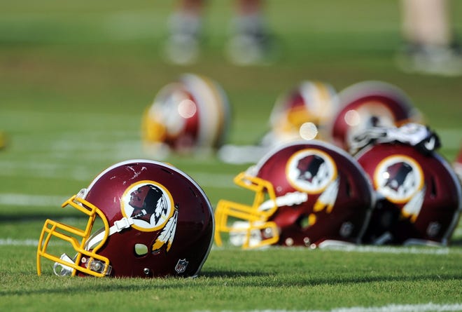 In this June 17, 2014, file photo, Washington Redskins helmets sit on the field during an NFL football minicamp in Ashburn, Va. The U.S. Patent Office ruled Wednesday, June 18, 2014, that the Washington Redskins nickname is “disparaging of Native Americans” and that the team’s federal trademarks for the name must be canceled. The ruling comes after a campaign to change the name has gained momentum over the past year.