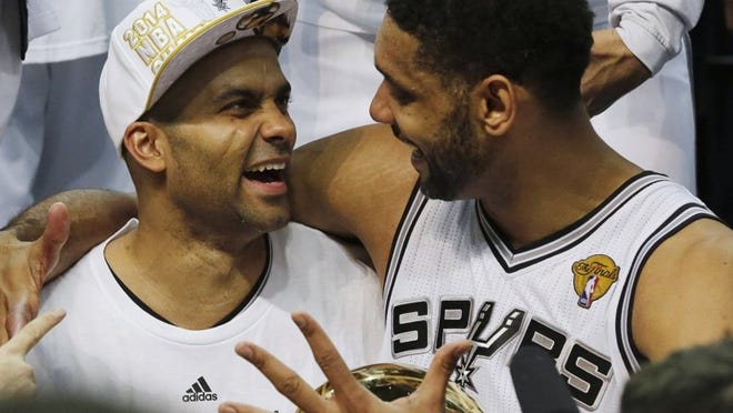 Spurs guard Tony Parker, left, and forward Tim Duncan celebrate San Antonio’s fifth NBA championship. Big 12 coaches hope the team’s selfless style trickles down to the college game.