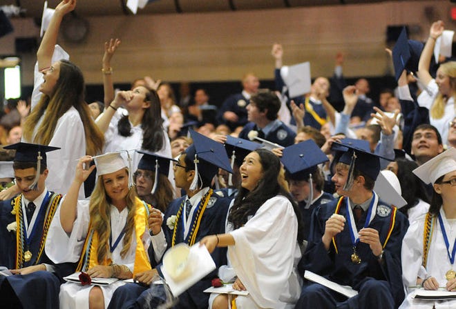 Graduates throw their caps after the conferral of diplomas during the Council Rock North graduation for the class of 2014 on Thursday night at the school. The graduation was moved indoors due to weather.