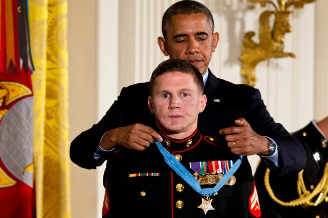 President Barack Obama awards retired Marine Cpl. William "Kyle" Carpenter, the Medal of Honor for conspicuous gallantry, Thursday, June 19, 2014, during a ceremony in the East Room of the White House in Washington. Carpenter received the Medal of Honor for his courageous actions while serving as an Automatic Rifleman in Helmand Province, Afghanistan.