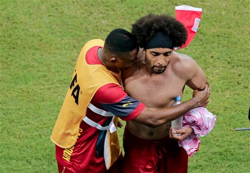 Cameroon's Benoit Assou-Ekotto, right, is comforted after losing 0-4 to Croatia during the group A World Cup soccer match between Cameroon and Croatia at the Arena da Amazonia in Manaus, Brazil, Wednesday.
