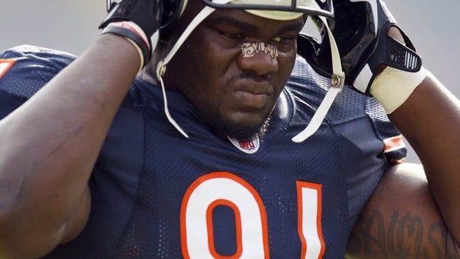 In this November 2009 file photo, Chicago Bears defensive tackle Tommie Harris adjusts his helmet during warm-ups before a game against the Arizona Cardinals. Former NFL players Tommie Harris and Eric Bassey are the first owners of a team in the new FXFL developmental league, which plans to launch in October as a developmental league, with no NFL affiliation but with lots of intriguing ideas. Harris and Bassey will own the Austin franchise, with other teams to be located in the New York and Boston areas; Omaha, Nebraska; Portland, Oregon; and a city in Florida yet to be determined.