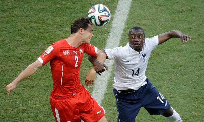 Switzerland's Stephan Lichtsteiner, left, and France's Blaise Matuidi go for a header during the group E World Cup soccer match between Switzerland and France at the Arena Fonte Nova in Salvador, Brazil, Friday, June 20, 2014.
