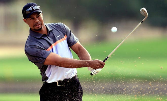Tiger Woods hits a bunker during the first round of the Dubai Desert Classic in Dubai, United Arab Emirates in January. (THE ASSOCIATED PRESS)