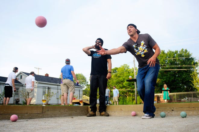 AJ Jewett bowls a bocce ball as Ryan Thomas waits his turn during a match Friday night at Logboat Brewing Co. Hitting its first summer in operation, the brewery will be hosting leagues for both bocce and croquet on the wide lawn in front of its facility.