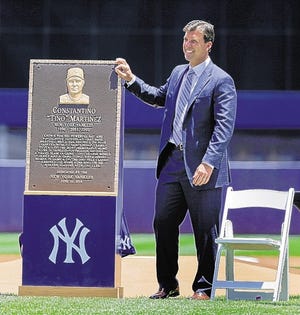 Former Yankees first baseman Tino Martinez stands next to a plaque dedicated to his time with the team.