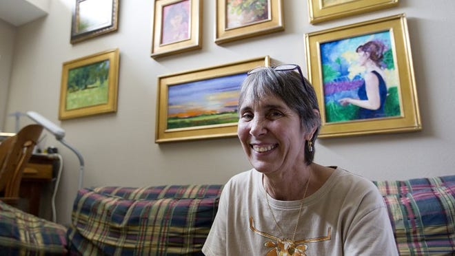 Kathleen McElwaine sits on her couch surrounded by her paintings in this June 2012 photo. ALBERTO MARTINEZ / AMERICAN-STATESMAN