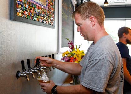 Greg Campbell, owner operator of High Tide Brewing Company in Jacksonville, pours a Blonde Ale from the tap. The beer is brewed on site at High Tide Brewing Company on Thursday afternoon.