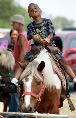 Jermiah Jackson rides a pony Sunday, July 1, 2012, during the Heritage Day festival behind Dari Ripple in Belvidere.