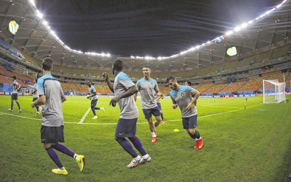 In this photograph taken with a fisheye lens, Portugal's Cristiano Ronaldo, cetner right, works out with teammates during a training session at the Arena da Amazonia in Manaus, Brazil, Sunday, June 22, 2014. Portugal will play against the United States in group G of the 2014 soccer World Cup on June 22.