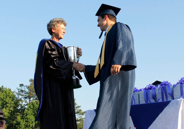 ‘PINNACLE OF OUR WORK’ — Dr. Diane Frost, Asheboro City Schools’ retiring superintendent, presents Brian Edward Conrad with the C.C. Cranford Citizen Award at Asheboro High School’s Class of 2014 Graduation June 10 at Lee J. Stone Stadium. (Maria Richardson/The Courier-Tribune) 
 TIME TO LEAVE THE NEST — Dr. Diane Frost was superintendent the entire time the Classes of 2013 and 2014 were in school. ‘We invested 13 years in their preparation and now they’re birds being able to take flight,’ she says, spreading her arms like she was ready to soar, too. (Maria Richardson/The Courier-Tribune)