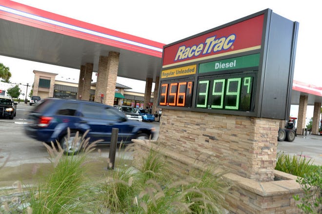 Cars pull into a gas station past a sign advertising fuel prices on State Road 19 in Eustis, Monday.