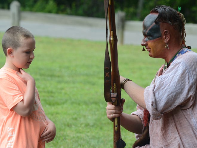 Will Caldwell, as a Cherokee warrior, talks with Preston Francis, 8, as they take part in a living history program from the French and Indian War and illustrated what life was like on the NC frontier during the war. Soldiers interpreted period military camp life and cooking and they also demonstrated the use of black powder flintlock muskets. The event was part of the 3rd Annual Movie on the Meadows at Chimney Rock State Park Saturday.