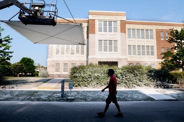 Crew members with the CBS TV series "Under The Dome" prep the facade of New Hanover High School for a winter scene in Wilmington, N.C., Thursday. ( Mike Spencer | Wilmington Star-News )