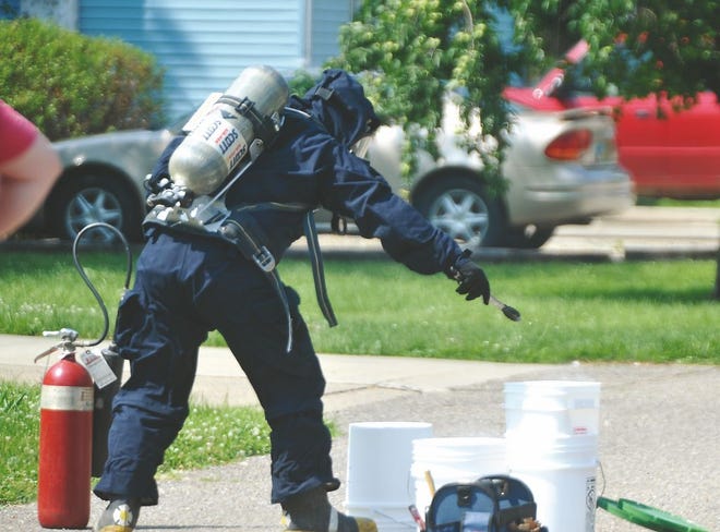 A member of the Holmes County Sheriff's Meth Lab Containment Unit works on dismantling the meth labs found in the trash Tuesday on Fourth Drive in New Philadelphia.